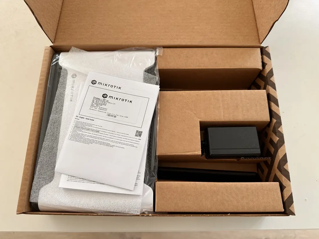 Unboxing MikroTik Chateau LTE12 — zawartość pudełka: router, instrukcja Quick Guide, zasilacz
